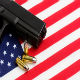 a gun an bullets sitting on an American Flag